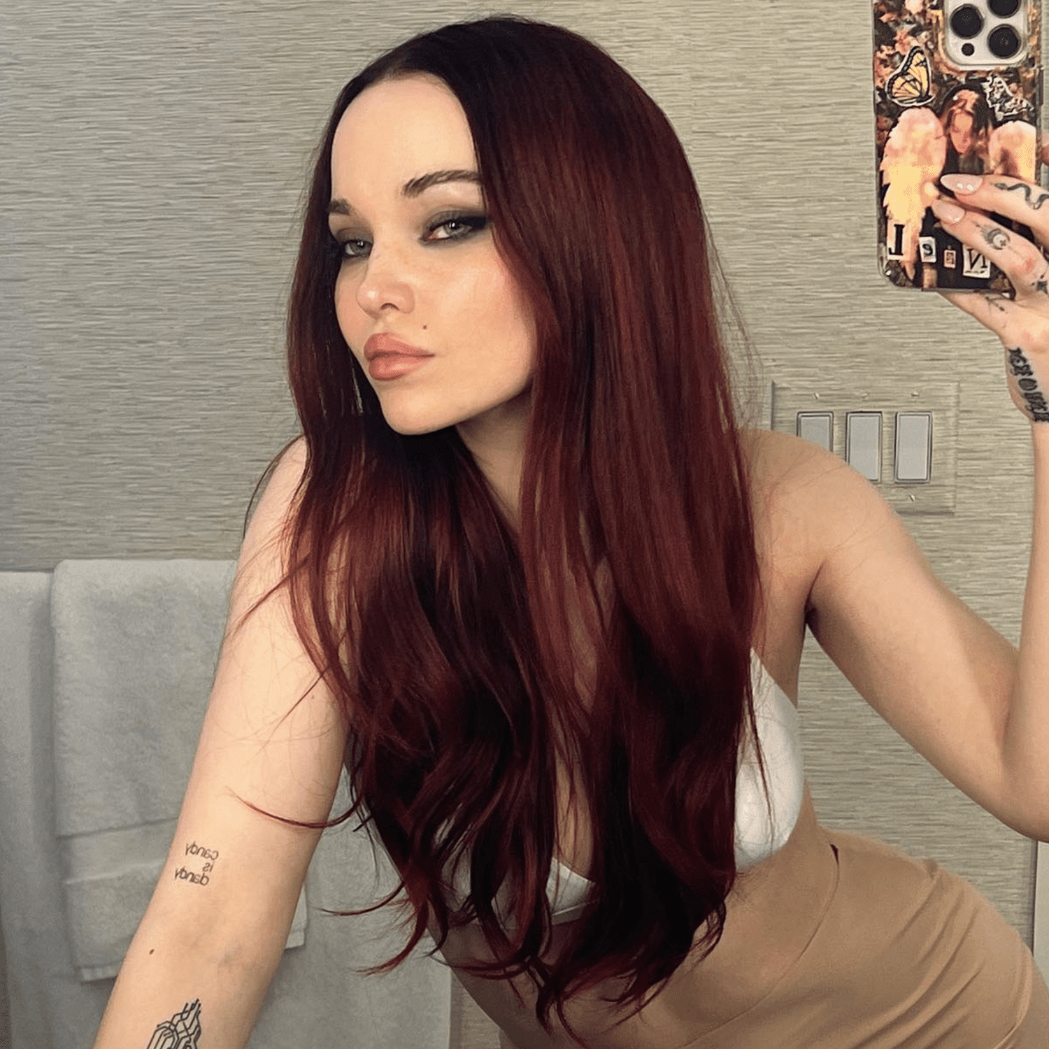 Dove Cameron with long deep red hair.