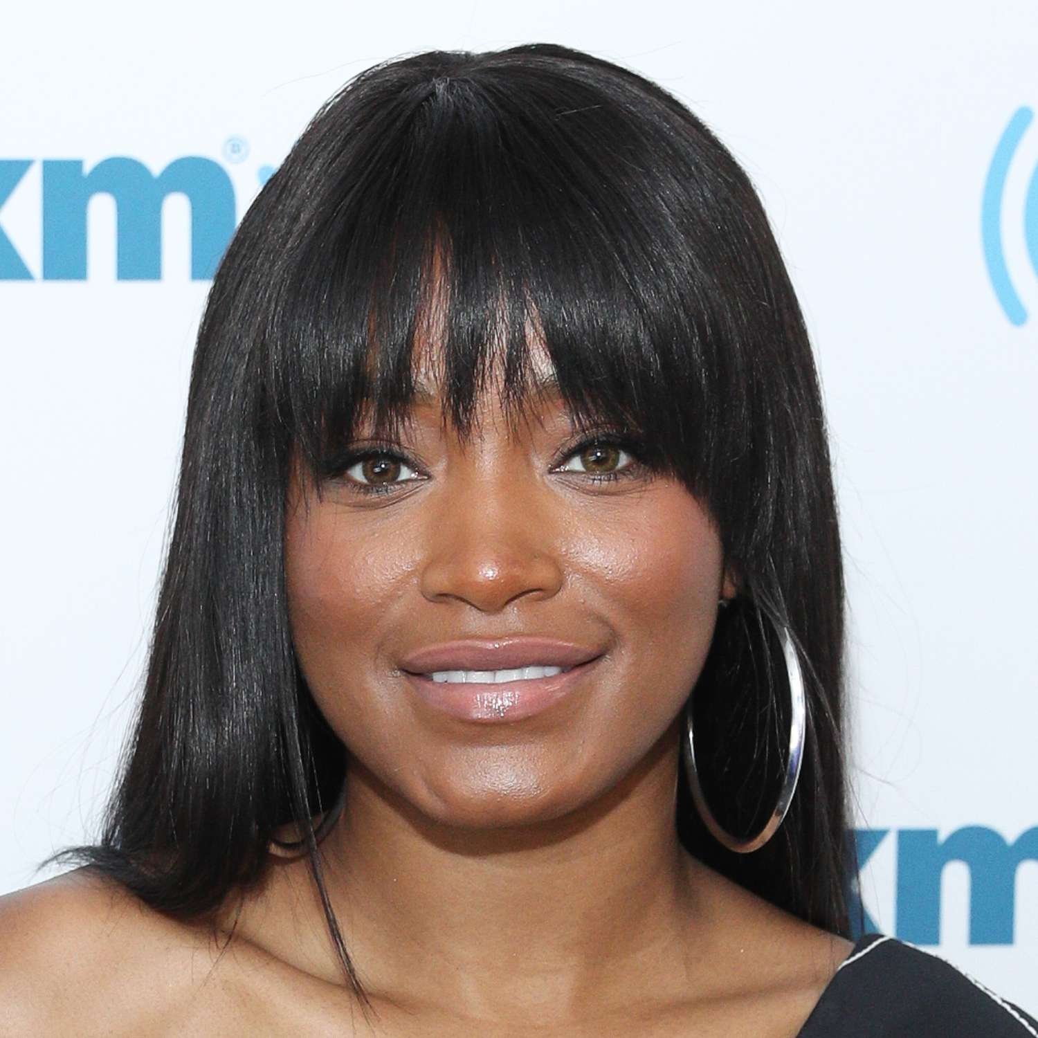 Keke Palmer wearing a heavy french bang and large silver hoop earrings to a NYC event